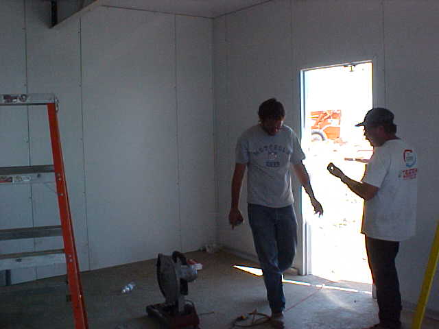 P Telcom workers tying wall to floor